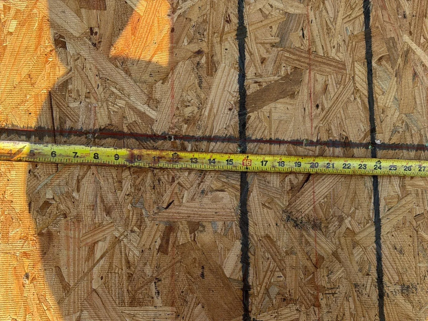 Chalk lines on new OSB decking with a tape measure across them
