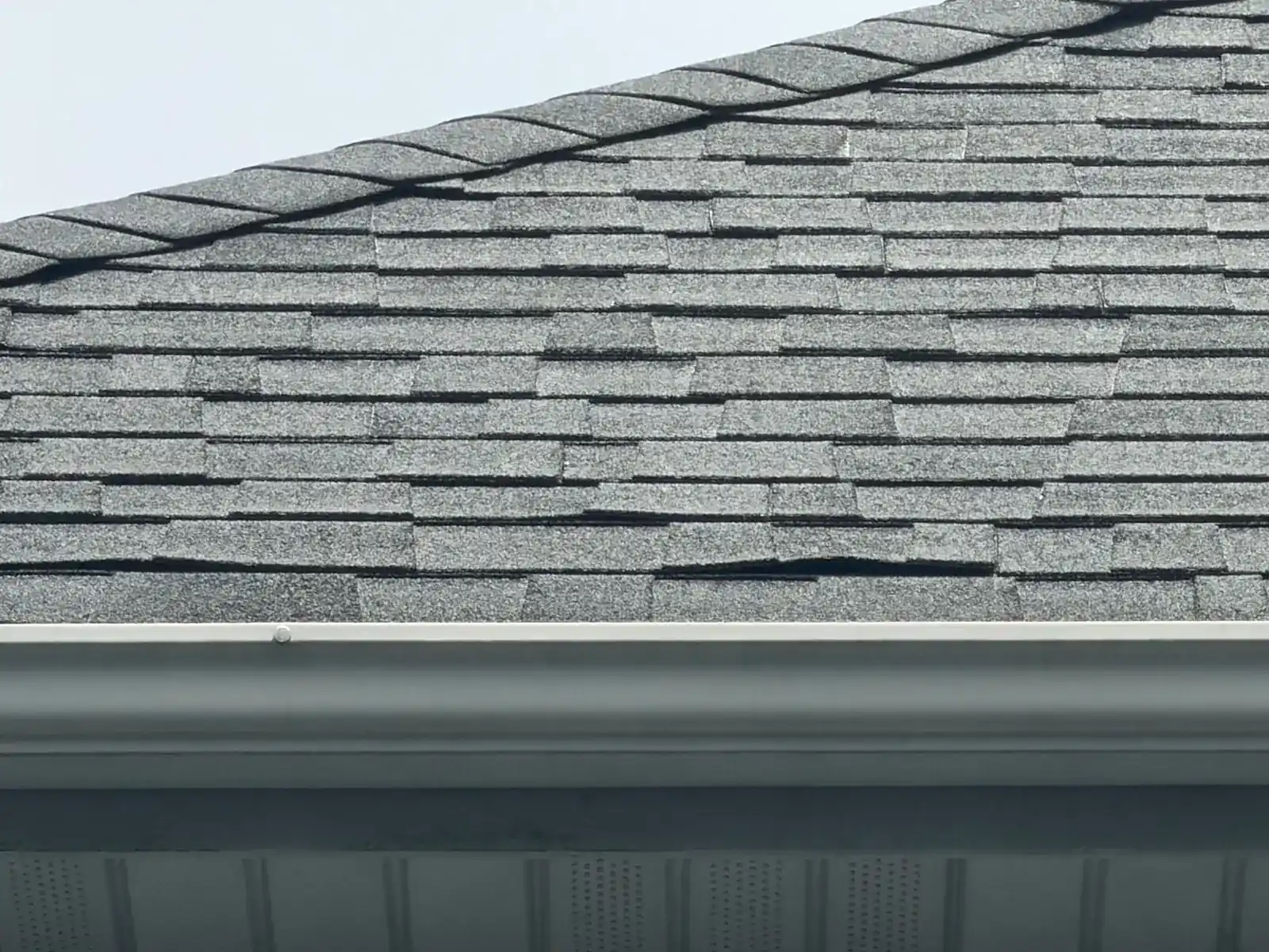 Close-up of worn shingles at the roof edge