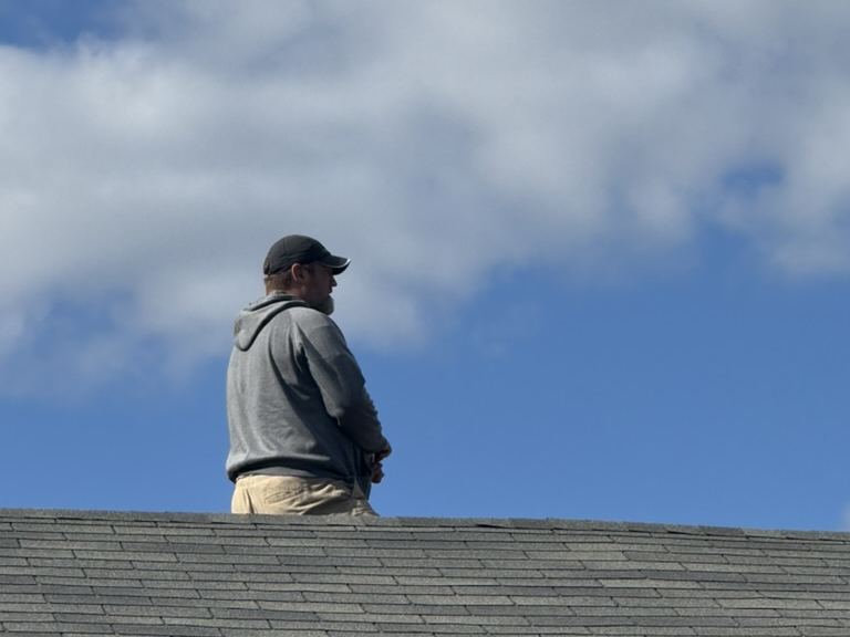 Addam Lewis on a roof ridge during an inspection