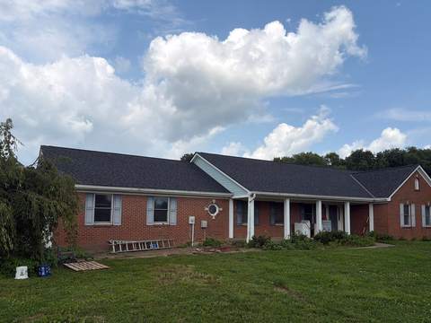 After: the same ranch from the front lawn with its new charcoal roof