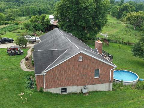 Before: one-story brick ranch from above, with its old dark shingle roof