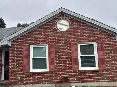 After: the front gable of the same ranch with a new gray shingle roof