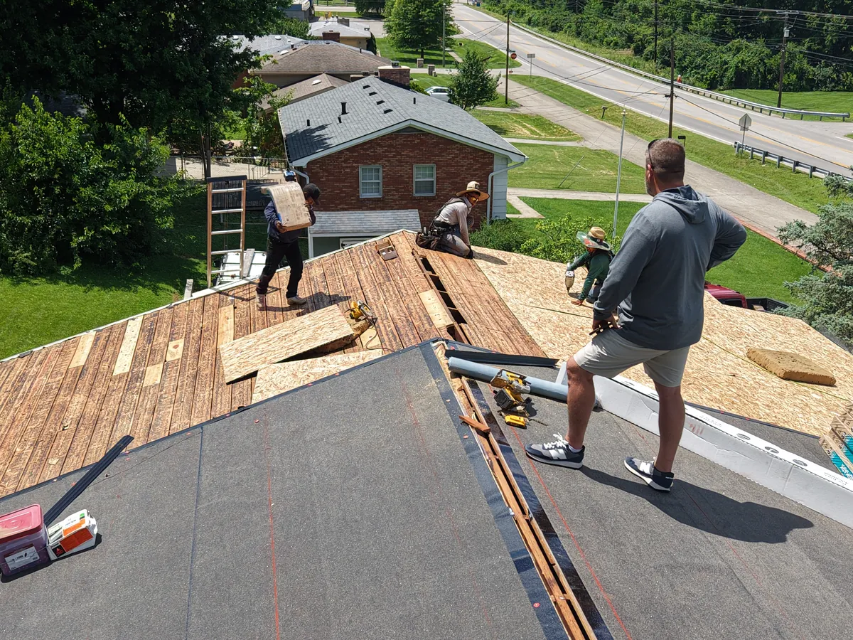 Addam, UNDERCOVER co-founder, on a roof overseeing a tear-off and re-deck